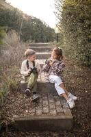 With vintage cameras resting on their laps, they share a quiet moment, ready to freeze time in a single click. photo