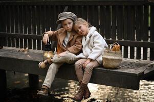 Dressed in vintage clothing, with old lighter the kids sit on a rustic bridge, breaking a baguette as sunlight filters through the trees. photo
