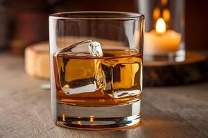 A glass of whiskey with ice cubes on a table photo