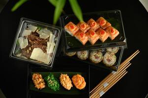 The rich colors of salmon, tuna, and avocado contrast against the deep black tableware, creating a perfect harmony of flavor and presentation. photo
