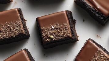 A close up of chocolate brownies on a white surface photo