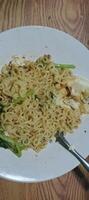 Instant noodles with vegetables and egg.A plate of instant noodles mixed with vegetables and egg, offering a simple and delicious homemade meal. photo