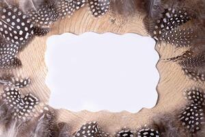 Flat lay blank greeting card mock up easter on a wooden background and feathers around. photo