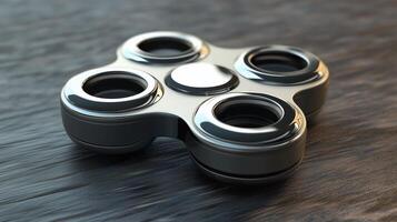 Shiny black fidget spinner with four circular cutouts resting on a textured wooden surface reflecting light and shadows photo