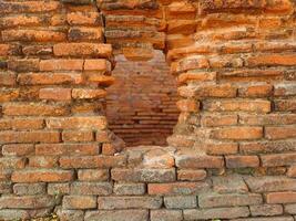 Hole in the ancient brick wall, ancient red brick texture, antique. photo
