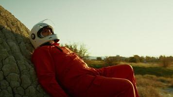 Exhausted Astronaut Collapses On A Rock With Helmet On An Empty Planet video
