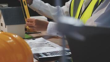 A man in a safety vest is working on a model of a house video