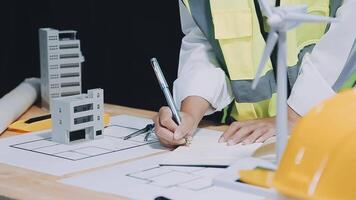 A person in a hard hat and safety vest is writing on a piece of paper video