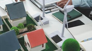 A person is working on a laptop and a model of a house video