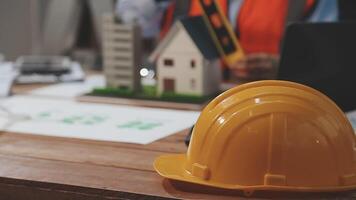 A hard hat sitting on a table with a construction project video
