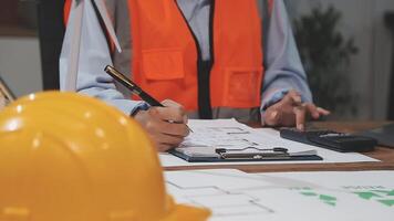A man in an orange vest and hard hat is working on a project video
