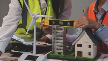 Two people working on a model of a house and wind turbine video