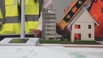 A man and woman are working on a model of a house video