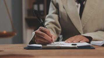 A person in a suit writing on a notepad video