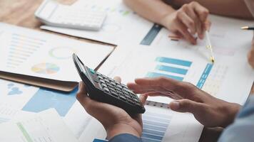 Business people using calculator and papers to calculate the financial data video
