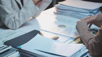 Two business people sitting at a desk with papers and papers video