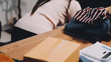 A woman is sitting on a table with a pile of clothes video
