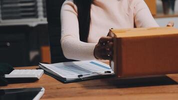 A woman is holding a box with a paper on it video
