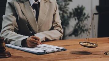 A lawyer writing on a notepad in front of a scale of justice video