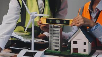 Two people working on a model of a house and wind turbine video