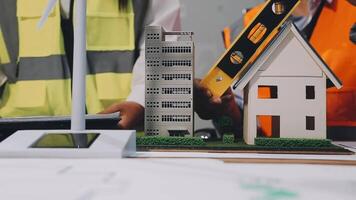 Two people working on a model of a house video
