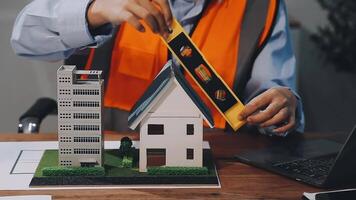 A man is working on a model of a house video