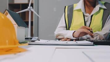 A woman in a hard hat and safety vest is working on a calculator video