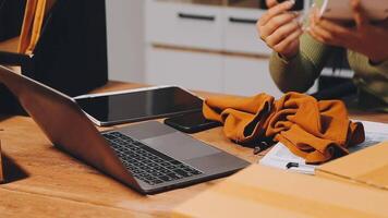 A woman is sitting at a desk with a laptop and a box video