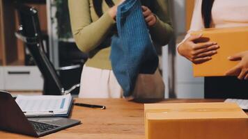 Two women are standing in front of a desk with boxes video