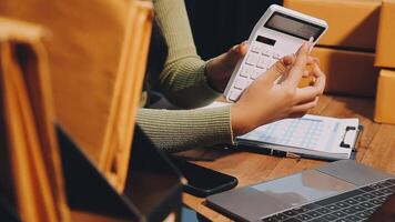 A woman is using a calculator to calculate the cost of a package video