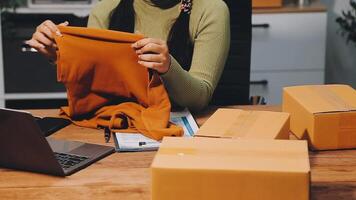 A woman is sitting at a desk with a laptop and boxes video