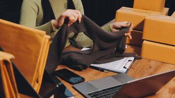 A woman is sitting at a desk with a laptop and a package video