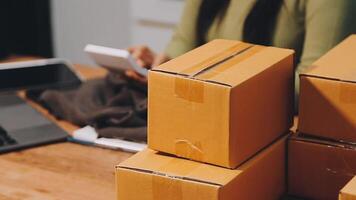A woman is using a laptop and a stack of boxes video