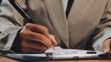 A person in a suit writing on a piece of paper video