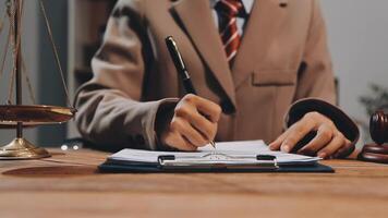 A man in a suit is writing on a piece of paper video