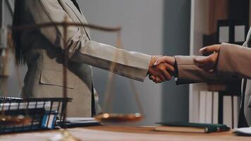Two business people shaking hands over a desk video