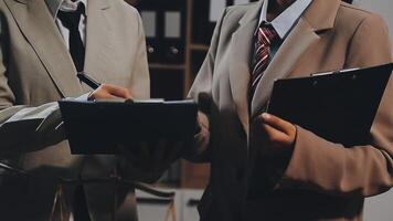 Two business people are talking while holding a clipboard video