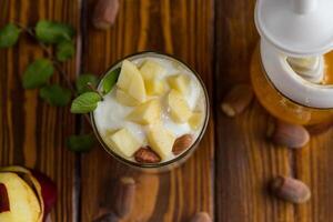 Top view . Diet breakfast. sweet homemade yogurt in a glass with apples, nuts and honey photo