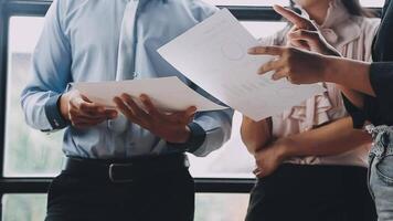 Three business people standing in front of a window video