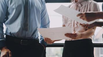 Three business people holding papers and looking at each other video
