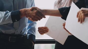 Two people shaking hands over papers video