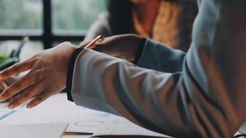 A person is holding a pen and pointing at a document video