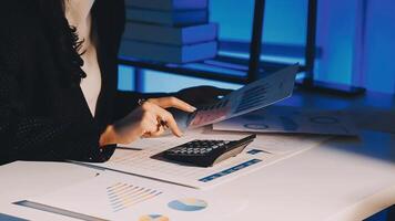 A woman is using a calculator and papers on a desk video