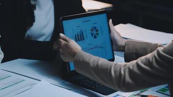 Business people working on a laptop with graphs and charts video