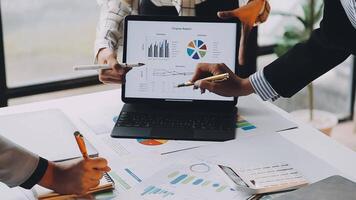 Business people working on a laptop with graphs and papers video