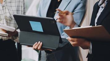 Three business people holding a tablet computer video