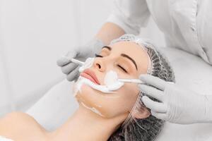 A serene woman receiving a moisturizing facial oxygen foam applied by a beautician in a spa setting, promoting relaxation and skincare photo