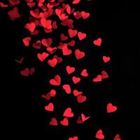 Falling Red Heart Shapes Over Black Background, Representing Love and Affection photo