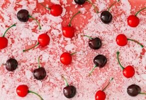 Trendy summer pattern made of red cherries in liquid white and red background. Minimal summer fruit concept. Cherry fruit aesthetic. Nature flat lay. Top view backdrop image. photo