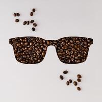 Coffee beans visible through glasses shaped cutout on white background. Minimal coffee concept. Coffee aesthetic. Flat lay, top view. photo